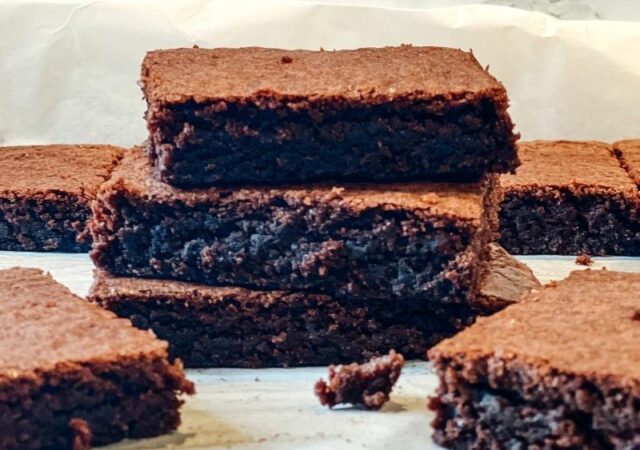 Συνταγή για τα καλύτερα σπιτικά Brownies - Ζουμερά κομμάτια brownie με τραγανές άκρες που ξεχυλίζουν πλούσια γεύση σοκολάτας.